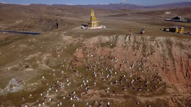 Big-Buddha-on-the-grass-hill-at-Yarchen-Gar-Monastery-in-Garze-Tibetan,-Sichuan,-China.