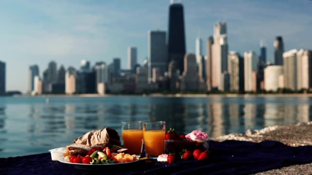 Close-up-view-of-fruits-and-juice-on-the-shore-of-Michigan-lake-in-Chicago,-America-in-sunny-bright-day