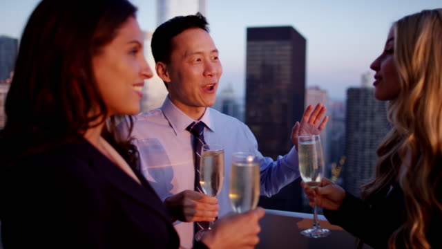 Multi-ethnic-managers-toasting-with-champagne-on-rooftop