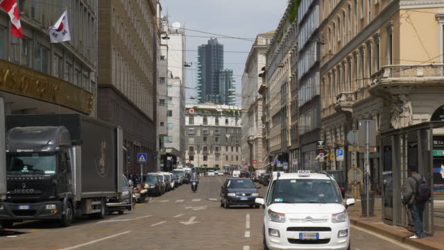 Panorama-de-calle-lenta-del-tráfico-de-ciudad-de-Italia-día-soleado-Milán-4k