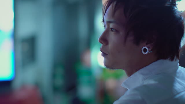 Portrait-of-the-Handsome-Japanese-Alternative-Man-with-Piercing.-In-the-Background-Big-City-Advertising-Billboards-Lights-Glow-in-the-Night.