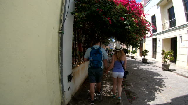 Tourist-couple-walking-down-street-in-Old-Havana-Cuba