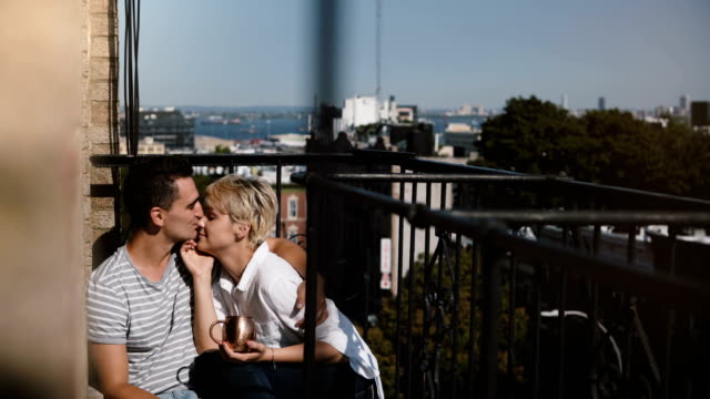 Glücklich-entspannt-multiethnischen-romantisch-zu-zweit-sitzen-nahe-beieinander-an-einem-schönen-sonnigen-Morgen-Balkon-in-New-York