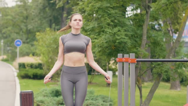 Fitness-Frau-training-im-Freien-mit-Springseil-im-Sommerpark.