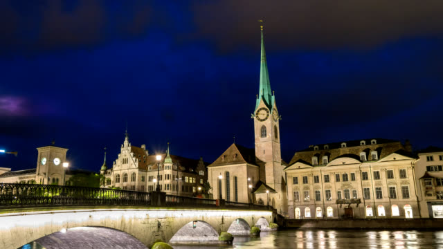 Lapso-de-tiempo-de-Suiza-Zurich-4K,-ciudad-skyline-noche-timelapse-en-la-iglesia-de-Fraumunster-y-puente-de-Munster