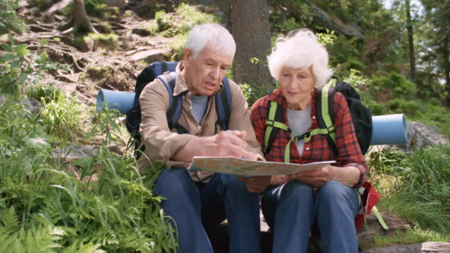 Elderly-Hikers-Checking-Route-on-Map-in-Forest