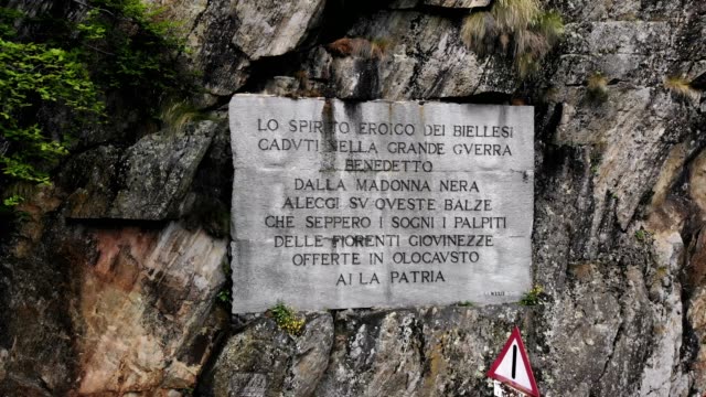 OROPA,-BIELLA,-Italien---7.-Juli-2018:-aero-Blick-auf-schöne-große-Inschrift-auf-Felsen-in-der-Nähe-von-Schrein-von-Oropa,-Heiligtum-befindet-sich-in-Bergen.-Touristen-zu-Fuß-im-Park-in-Bergen