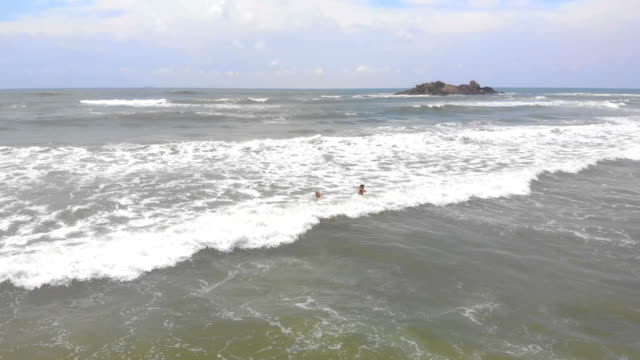 Die-drei-Mädchen,-die-Spaß-in-den-Wellen-des-Ozeans-in-Sri-Lanka