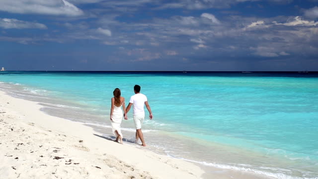 Young-beautiful-newlyweds-on-white-sandy-beach