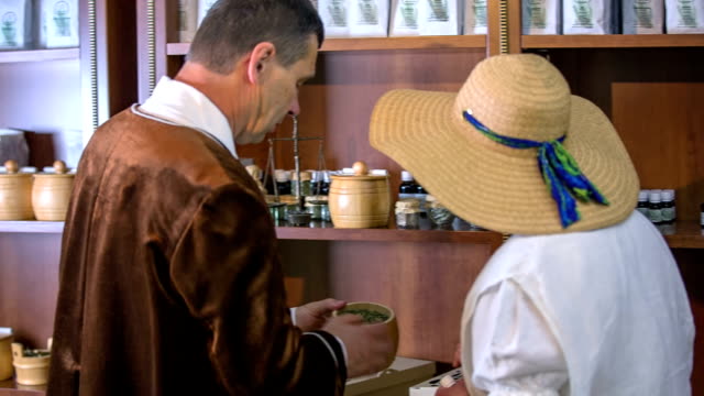 Man-brings-the-jar-with-herb-to-the-woman-to-check