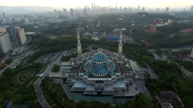Luftbild-von-Sonnenaufgang-im-Federal-Moschee-Kuala-Lumpur-mit-Blick-auf-die-Skyline-der-Stadt-im-Hintergrund.