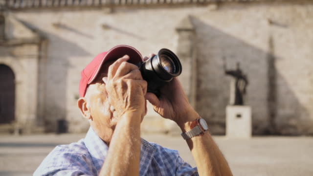 Old-Man-Tourist-Taking-Souvenir-Picture-With-Photo-Camera-In-Cuba