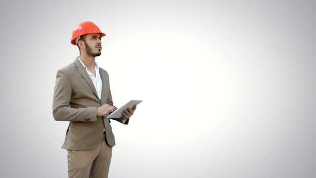 Ingenieur-in-der-Schutzhelmuntersuchung-mit-Tablet-auf-weißem-Hintergrund