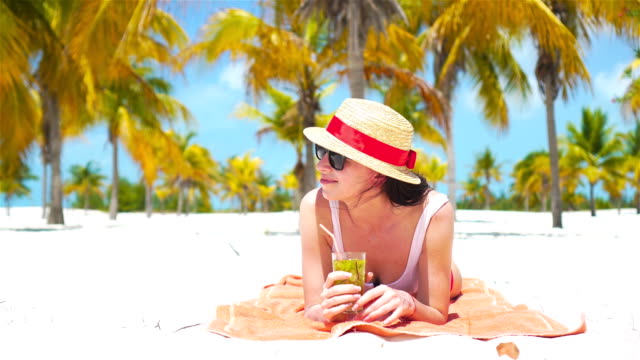 Junge-schöne-Frau-Entspannen-Sie-mit-einem-cocktail-auf-einem-weißen-tropischen-Strand