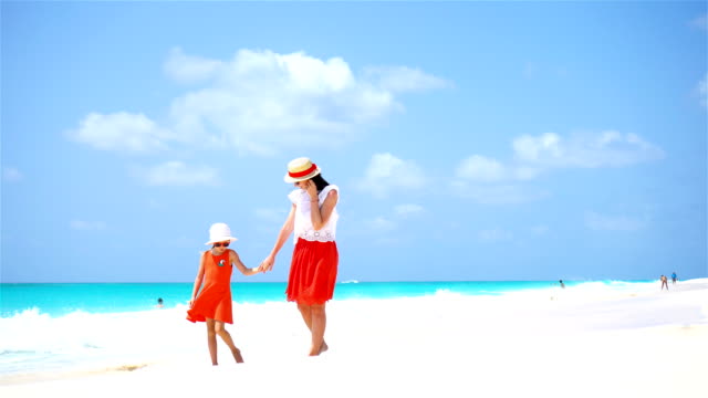 Little-cute-girl-and-young-mother-at-tropical-beach