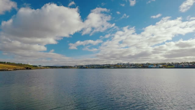 beeindruckende-Landschaft-mit-bewölktem-Himmel-und-das-Panorama-der-Stadt-Reykjavik-im-sonnigen-ruhigen-Wetter
