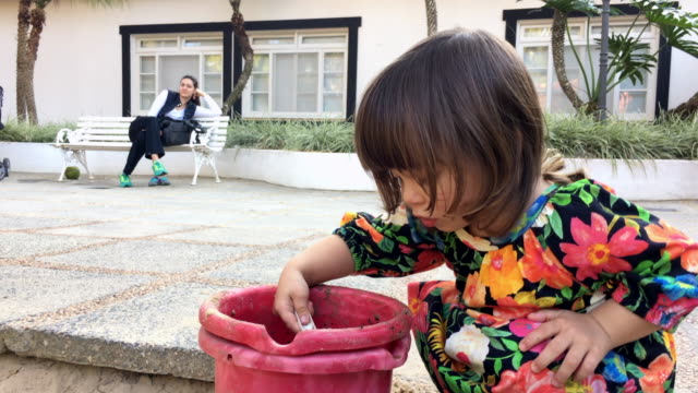 Candid-moment-of-little-girl-playing-with-toys-and-sandbox-tools-at-the-playground