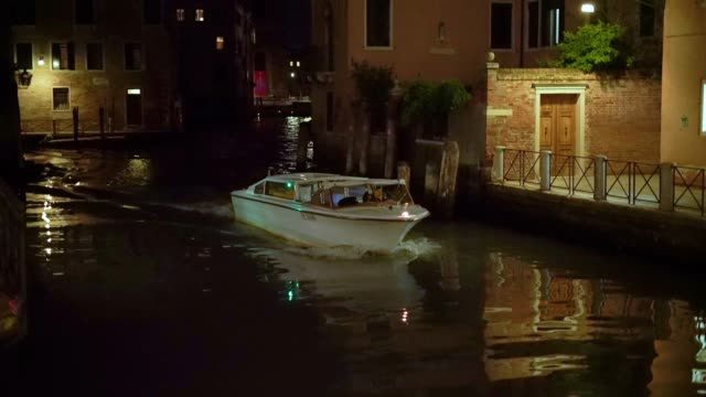 Barco-en-canal,-en-Venecia,-Italia-en-la-noche-en-cámara-lenta