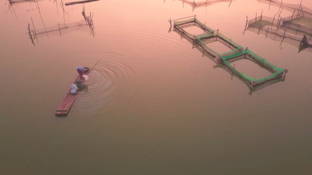 Pescadores-preparan-sus-redes-de-pesca-al-amanecer-para-la-captura-de-peces-en-Rowo-Apung-flotante-lugar-Jombor-Klaten,-Indonesia-Yogyakarta