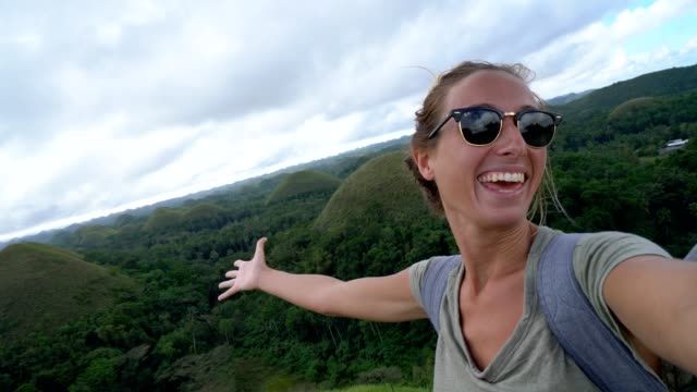 4K-video-of-woman-taking-selfie-at-Chocolate-Hills-of-Bohol,-Philippines