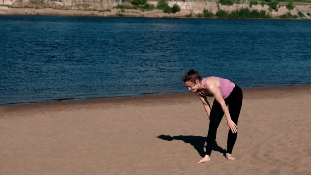 Mujer-haciendo-yoga-en-la-playa-por-el-río-en-la-ciudad.-Hermosa-vista.-Handstand.