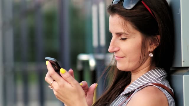 Comunicación-de-la-mujer-o-charlando-con-alguien-usando-el-smartphone-de-pie-cerca-de-edificio-moderno-de-cristal
