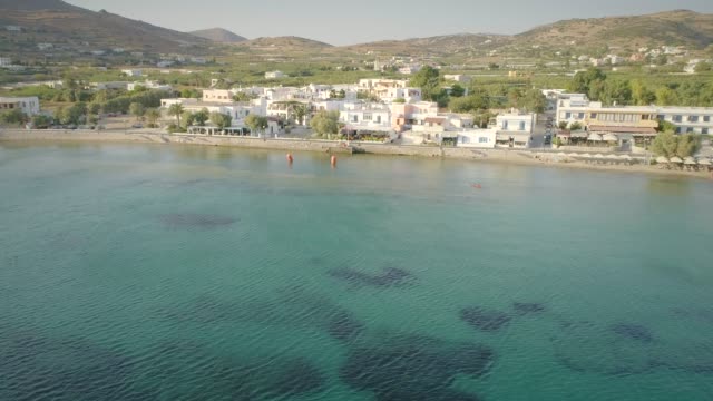 Aerial-view-of-large-white-villas-in-front-of-beach-at-Ydroussa,-Andros-island.