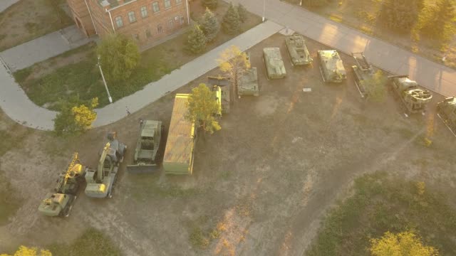 vista-aérea-de-fila-de-máquinas-vehículos-militares-durante-la-puesta-de-sol