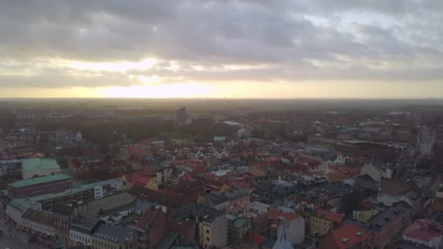 Aerial-view-of-Lund-city-and-Cathedral-church-building-at-sunset.-Drone-shot-flying-down-over-cityscape-skyline-and-church-tower-spire