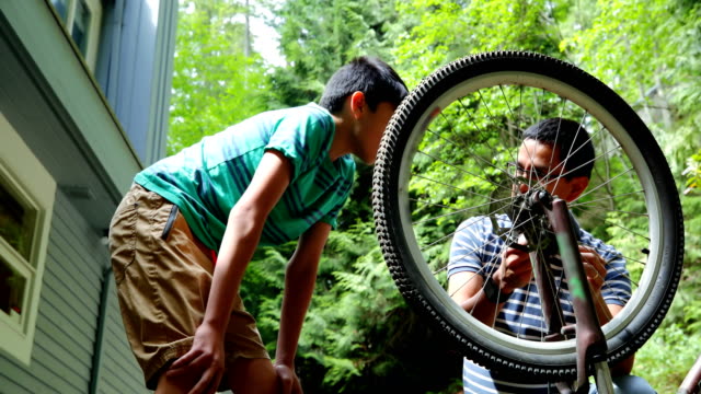 Father-and-son-repairing-bicycle-4k