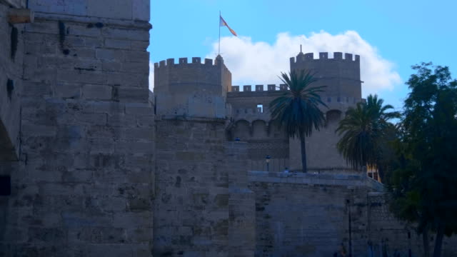 Beautiful-ancient-castle-with-graceful-serrated-towers-and-flag-of-Valencia