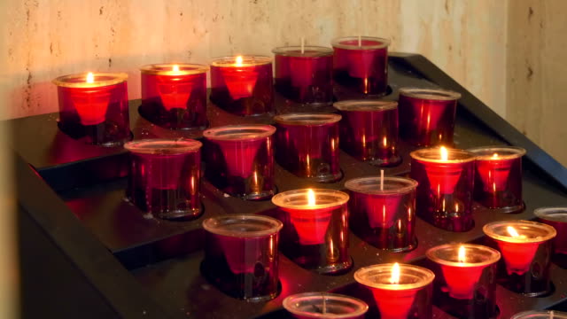 Reihen-brennender-Kerzen-in-roter-Form-in-einer-Kirche-in-Spanien