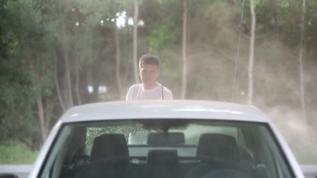 Man-in-a-t-shirt-white-car-washes.-Slow-motion