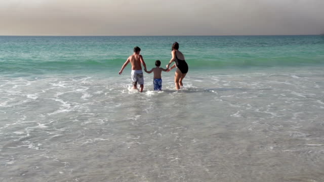 Madre-y-dos-niños-corriendo-en-el-mar,-la-Ciudad-del-Cabo,-Sudáfrica