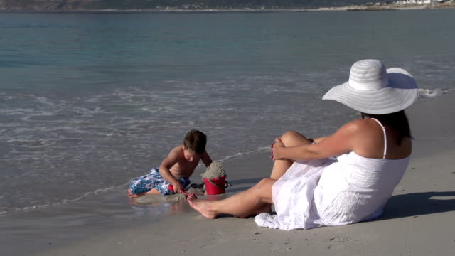 Junge-am-Strand-spielen,-während-die-Mutter-looks-auf,-Cape-Town