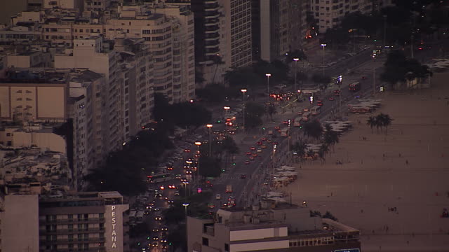 Busy-city-street-by-Copacabana-Beach-at-dusk,-Rio-de-Janeiro,-Brazil