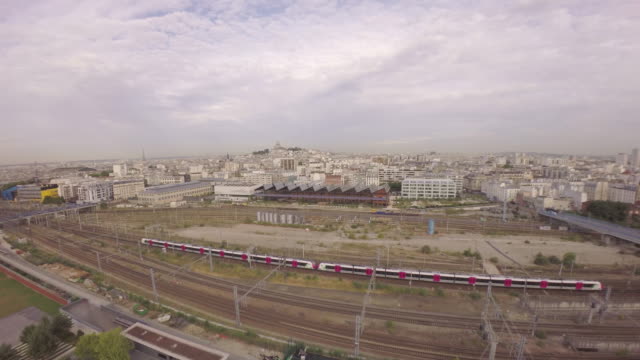Paris,-10.-Arrondissement-–-Luftbild-von-TGV-high-speed-Zug-vorbei-am-Bahnhof-Gare-Du-Nord-in-Halle-Pajol-und-die-Skyline-der-Stadt-im-Hintergrund.