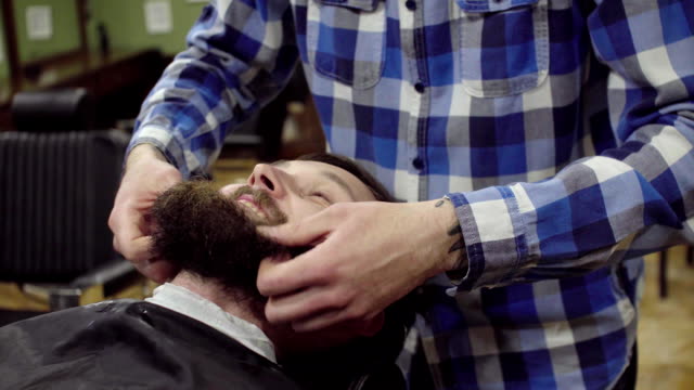 Barber-ist-Bart-ein-bärtiger-Mann-mit-Haartrockner-in-einen-Friseurladen-trocknen.