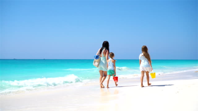 Entzückende-kleine-Mädchen-und-junge-Mutter-am-weißen-Strand
