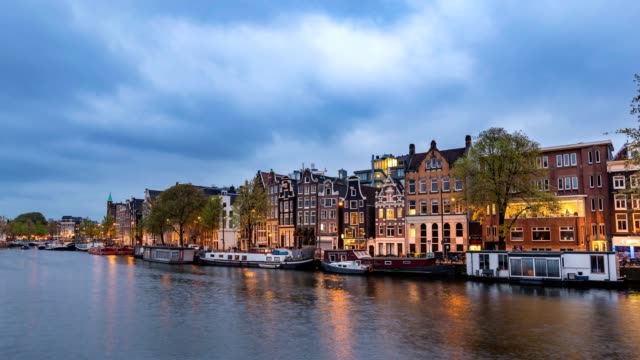 Amsterdam-Stadt-Skyline-von-Tag-zu-Nacht-Zeitraffer-im-Kanal-Waterfront,-Amsterdam,-Niederlande,-4-K-Zeitraffer