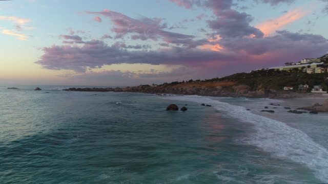 Antena-del-cabo-campos-Bahía-playa-con-hermosa-puesta-de-sol-rosa-sobre-rocas