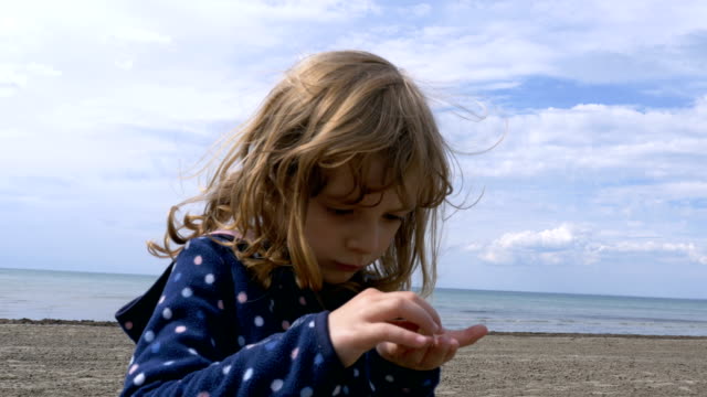 Kleines-Mädchen-am-Ufer-des-Lake-Ontario-mit-Kieseln-spielen