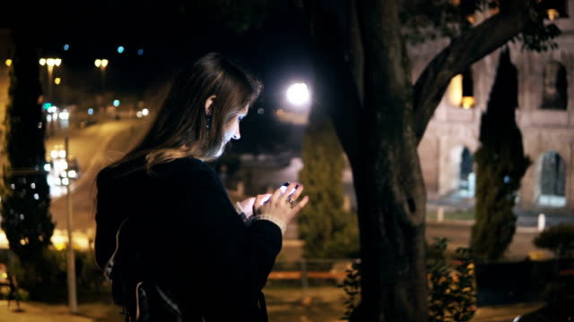 Junge-schöne-Frau-stehen-im-Zentrum-Stadt-nahe-dem-Kolosseum-in-Rom-und-mit-dem-smartphone