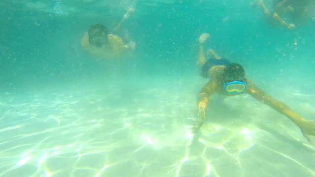Underwater-boys-swim-towards-camera-with-snorkel-masks