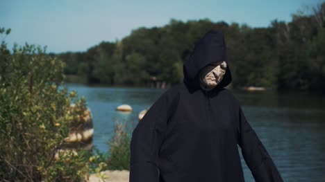 Eerie-witch-on-river-bank-watches-the-camera.