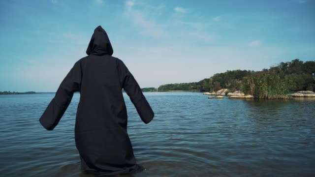 Terrible-witch-in-black-mantle-in-the-water-outdoor.