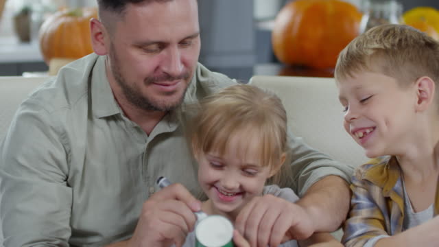 Smiling-Man-Drawing-on-Party-Cup-with-Children