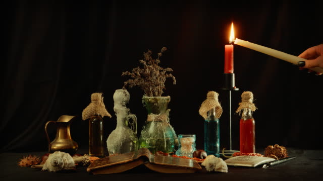Lighting-candlestick-on-table-with-witchcraft-objects