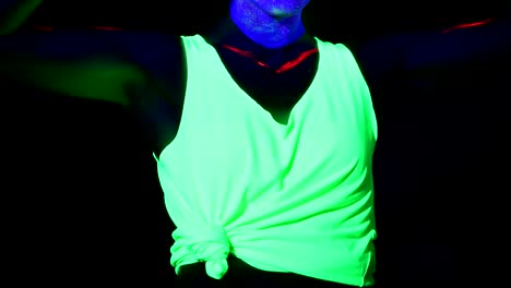 Woman-with-UV-face-paint,-glowing-clothing-dancing-in-front-of-camera,-body-shot.-Caucasian-woman.-.