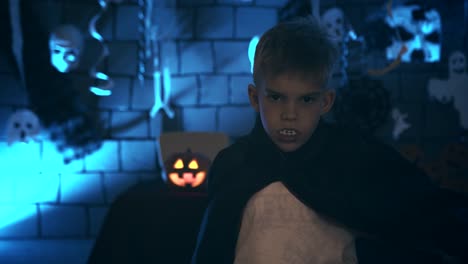 Young-boy-in-a-vampire-costume-for-Halloween-showing-his-scary-face-and-teeth-to-camera